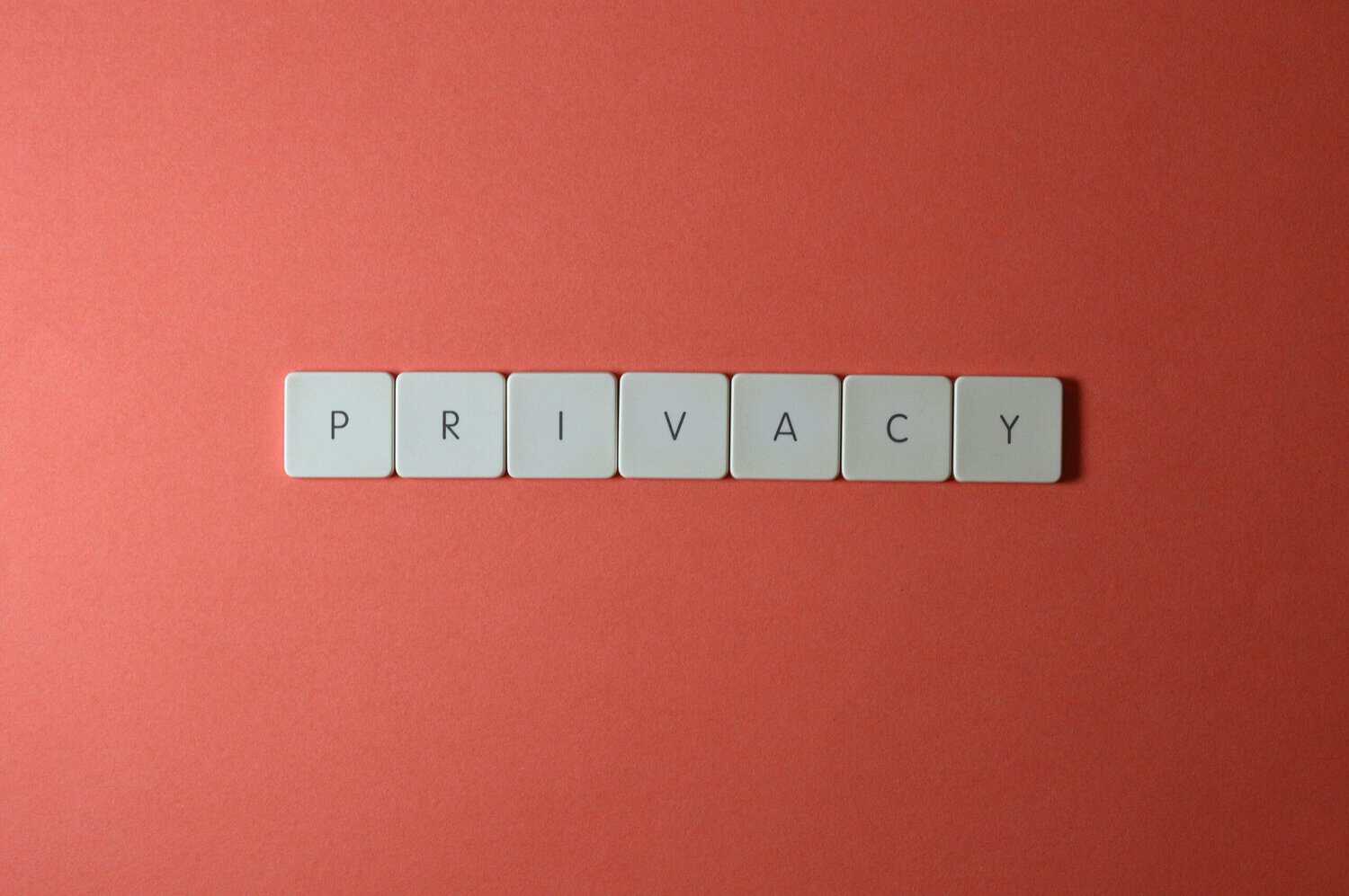 Close-up of letter tiles spelling PRIVACY on a red background, symbolizing data protection.